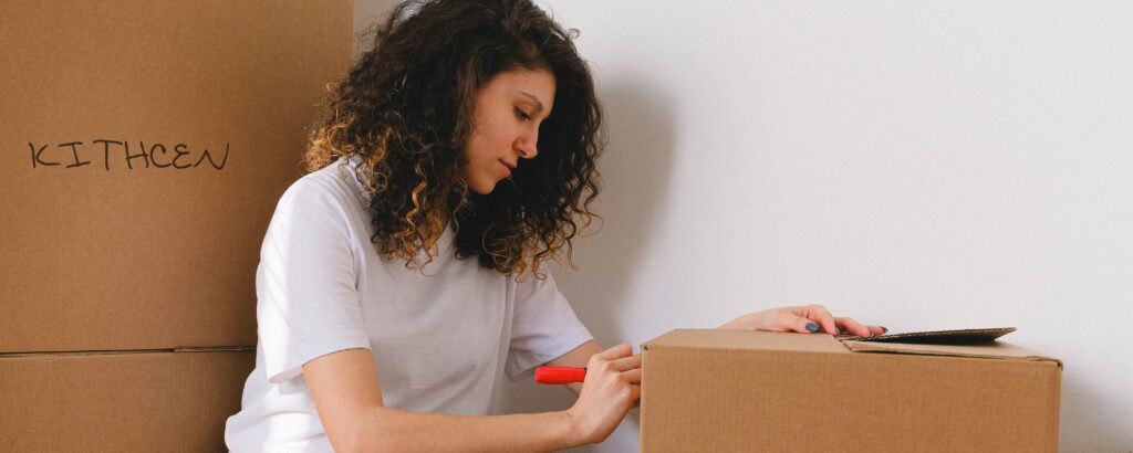 Persona organizando objetos en cajas etiquetadas.